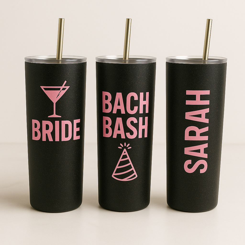 Three black tumblers with pink text and designs on a beige background