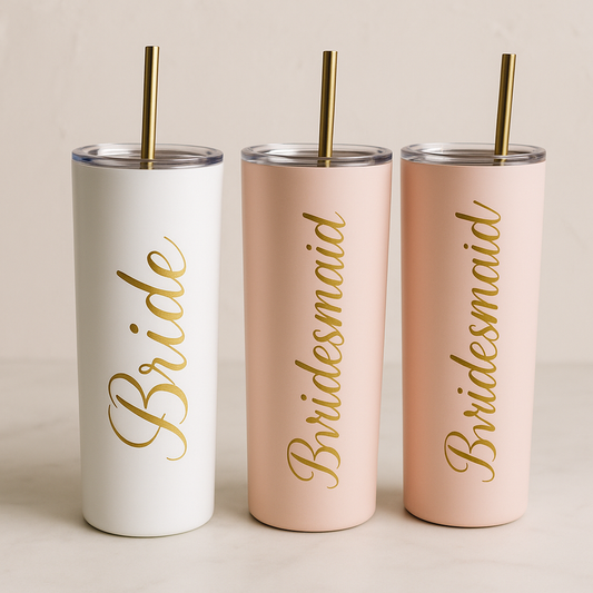 Three tumblers with 'Bride', 'Bridesmaid' text and gold straws on a neutral background